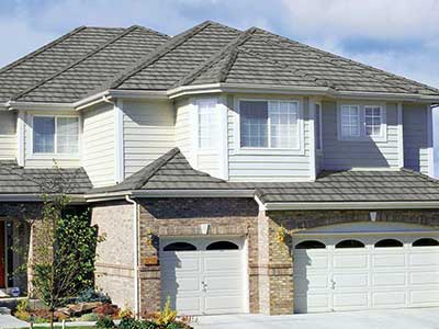Front side of a large two-story, mid-class home with gray Boral concrete tiles on its roof