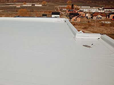 Close up of a flat white roof getting new materials installed