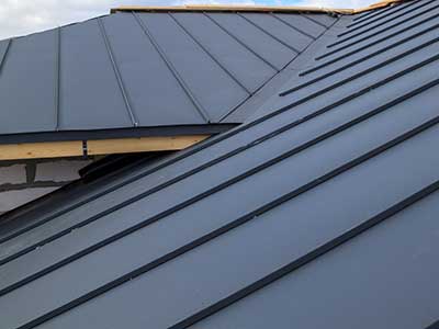 Close up of a dark gray metal roofing system on a home
