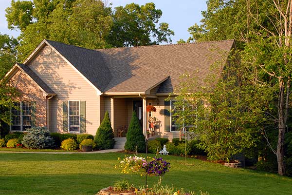 Mid-class beige home with light brown shingles on its roof
